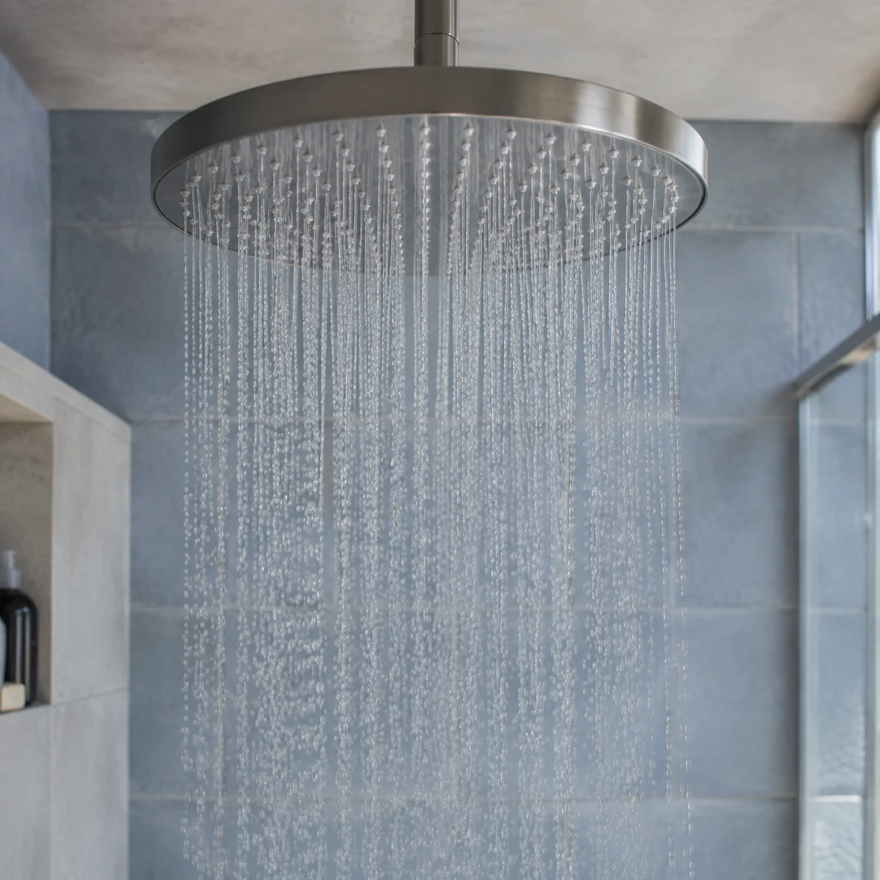 Water spreading from the nozzles of a wide overhead shower head
